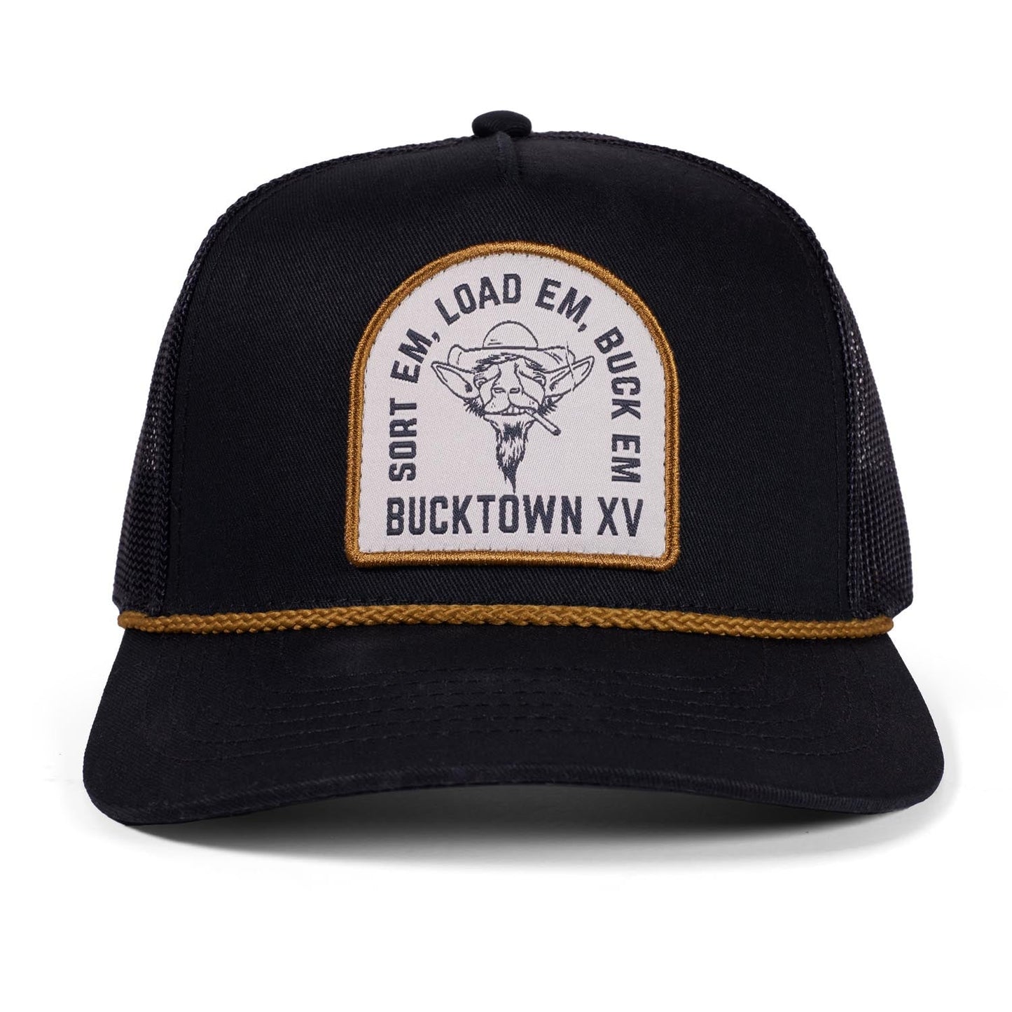 The G.O.A.T. Roper Hat by Rural Cloth is a black mesh trucker hat with a brown braided band and front patch showing a bull skull and “SORT EM, LOAD EM, BUCK EM BUCKTOWN XV,” inspired by the Bucktown XV Ranch.
