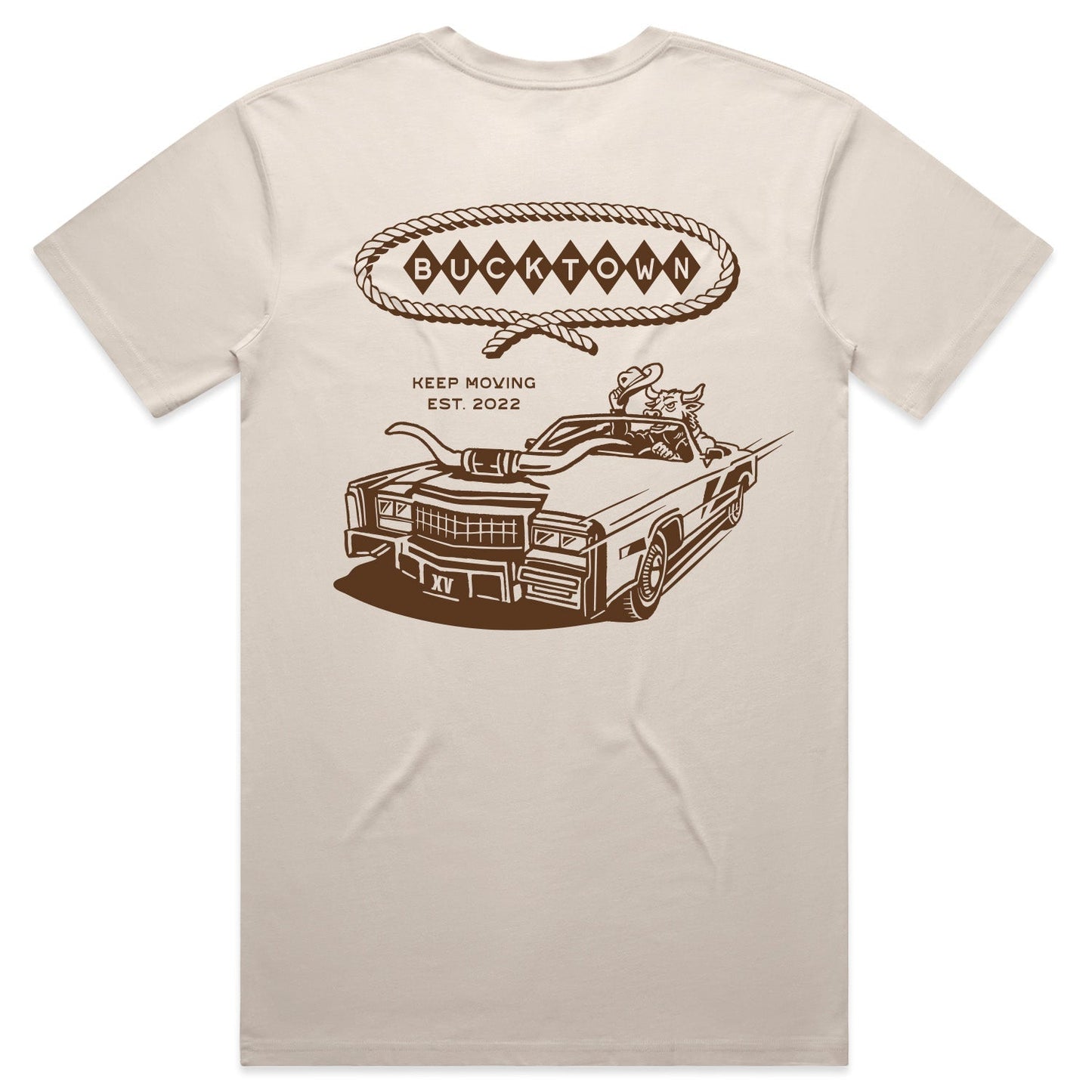 The Bucktown Caddie Tee by Rural Cloth in Bone features a graphic of a car full of animals, rodeo-inspired elements, and “BUCKTOWN” in a rope-bordered speech bubble on the back, plus “KEEP MOVING” and “EST. 2022.”.