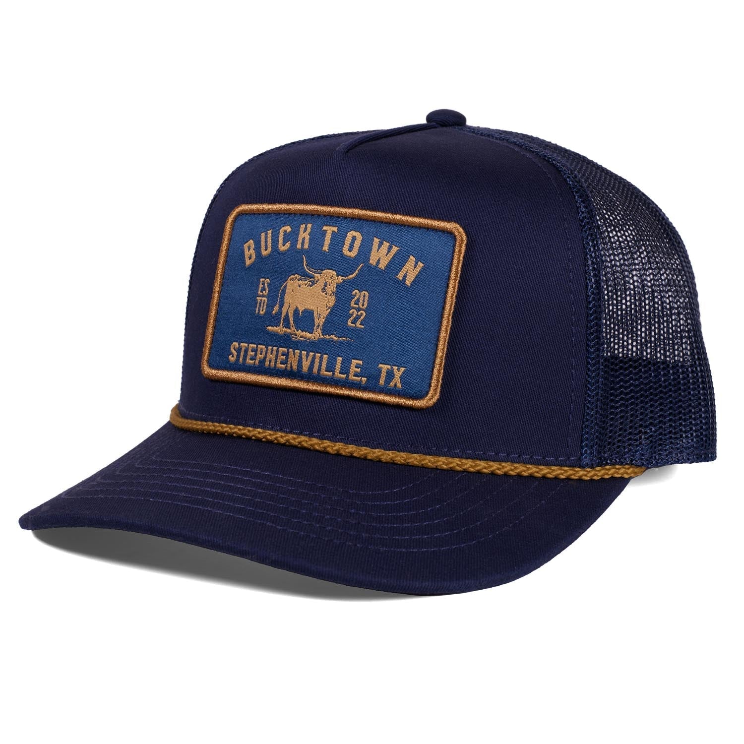 A navy blue Rural Cloth Stockman Hat trucker with an adjustable snapback, mesh back, and a front patch reading "Bucktown, Stephenville, TX" with a bull graphic and "ESTD 2022" in yellow—repping Bucktown XV Ranch.